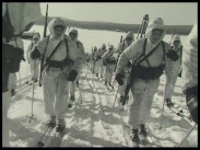 Skidande soldater i vinterutrustning på långa rader.