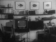 En äldre TV-apparat i ett vardagsrum med inredning från 1950-talet.