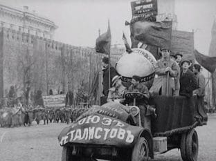 Traktor dekorerad med fanor och med banderoll över kylaren står på Röda Torget.