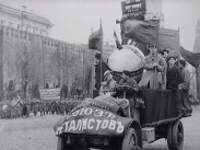 Traktor dekorerad med fanor och med banderoll över kylaren står på Röda Torget i Moskva.