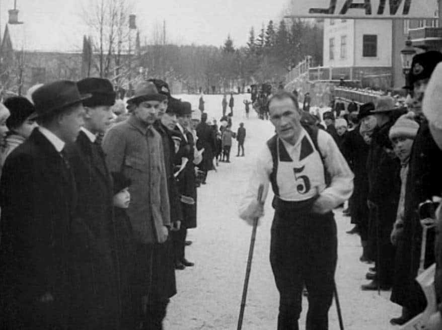 Skidlöpare med nr 5 på bröstet passerar publik.