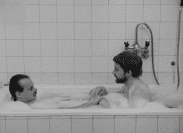 Två män badar skumbad i samma badkar.