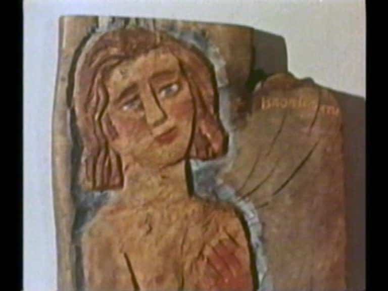 Kvinnohuvud och del av hennes överkropp, detalj av en figurtavla i trä av Bror Hjorth.