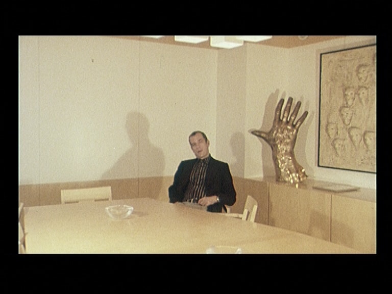 Jörn Donner vid konferensbord i Filmhuset med konstverk i bakgrunden.