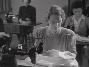 Stillbild ur Den sparade poängen som visar en kvinna sittandes vid en symaskin.