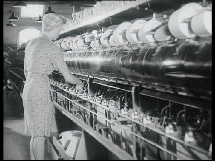 Kvinna vid textilmaskin.