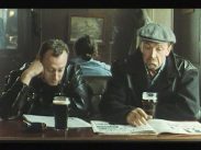 Två män med dystra miner på en pub med varsitt ölglas och varsin tidning.
