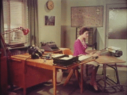En kvinna vid en kontorsmaskin på ett kontor i slutet av 1950-talet.