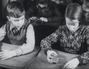 Barn i gammaldags skolbänkar med sparbössor.