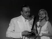 Illusionisten Hector El Neco tillsammans med sin kvinnliga assistent under framförandet av en trollkonst, båda klädda i vitt.