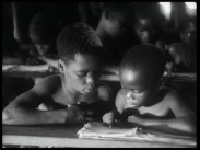 Två barn delar skolbänk i Kongo.