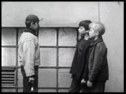 Tre pojkar i tolvårsåldern på en innergård.