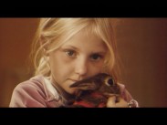 En liten flicka håller en kanin i famnen.