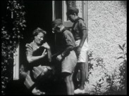 Två scoutpojkar bredvid en kvinna som håller en katt i famnen.