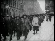 Deltagare i en marsch utmed snöiga Stockholmsgator.