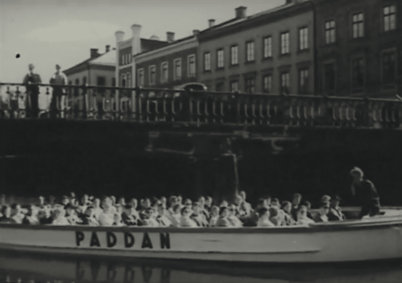 Rundtursbåten Paddan fylld med passagerare under en bro i Göteborg.
