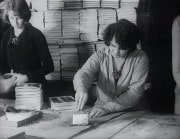 Två kvinnor på postorderföretaget Åhlén & Holm arbetar med katalogens tillkomst.