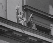 Kronprins Olav och prinsessan Märtha vinkandes på slottets balkong i Oslo.