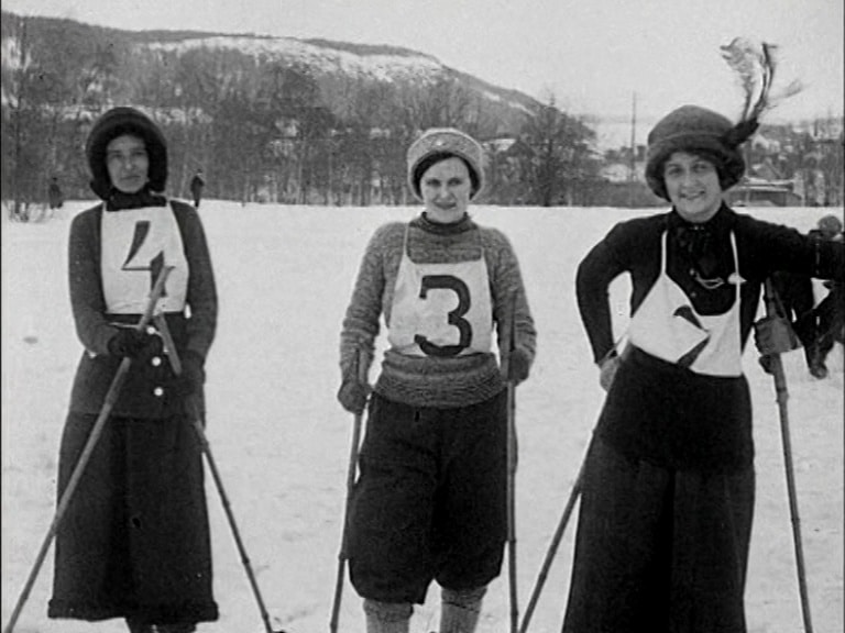 Tre kvinnliga skidåkare som tagit medalj i damernas tävling vid Östersund 1913 poserar efter loppet.