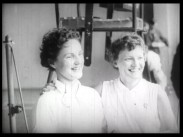 Två leende kvinnliga badmintonspelare i samband med SM-finalen 1958.
