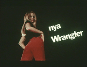 Ung kvinna visar upp moderiktiga röda jeans i reklamfilm. Texten "nya Wrangler" till höger i bild.