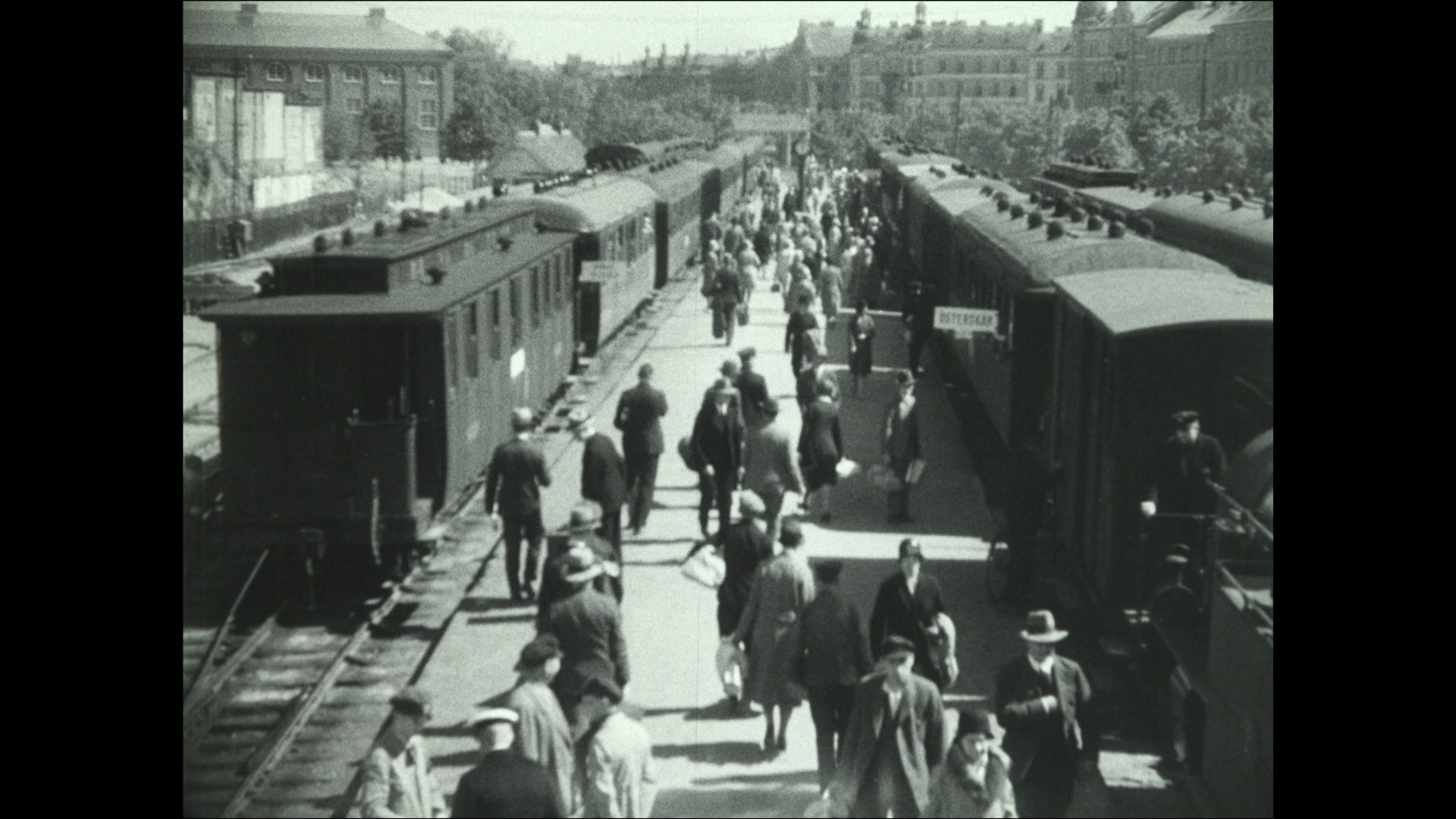 Människor på perrong och tåg som står inne vid Östra Station 1930.