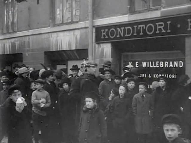 Paltbrödskö i huvudstaden från hungeråret 1917. Den långa kön övervakas av myndiga poliser i sina karakteristiska pickelhuvor.