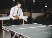 Olof Plame med racket vid pingisbord, klädd i vit skjorta med hängslen.