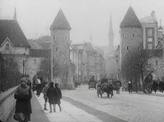 Stadsbild från Reval (dagens Tallinn): människor och hästskjutsar på gata, två tornbyggnader i bakgrunden.