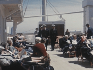 Fartygspassagerare och besättningmän i uniform på däck på en Amerikabåt på 1950-talet.