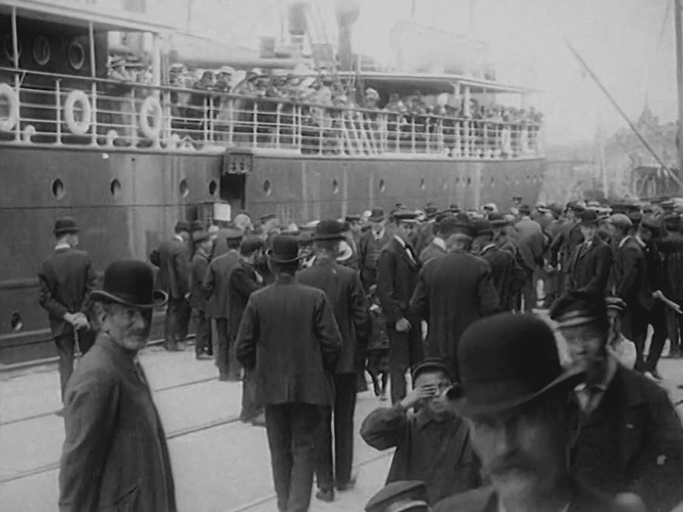 Bild från Göteborgs hamn 1909. Människor på kaj, fartyg i fonden.