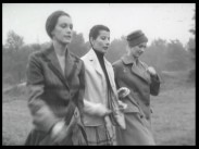 Tre promenerande kvinnor i moderiktiga kläder.