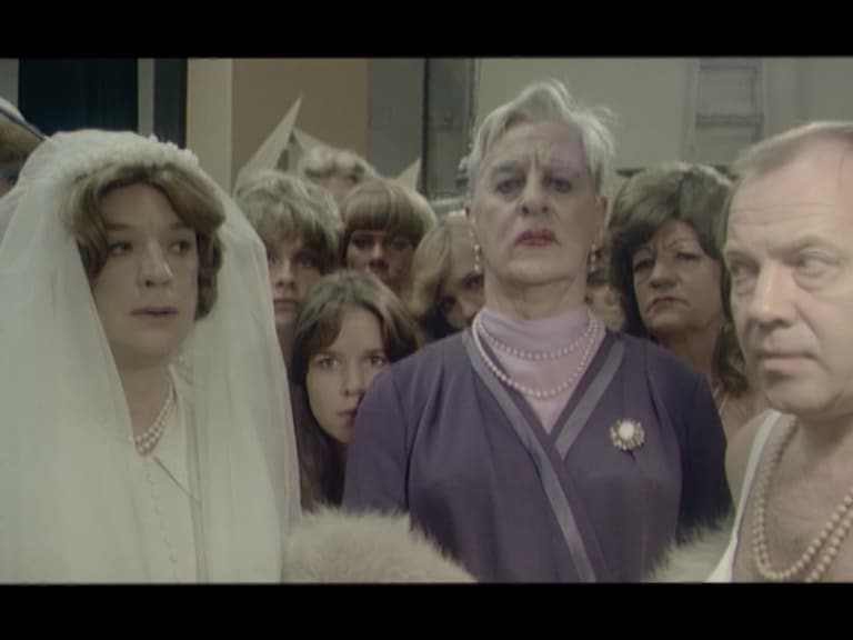 Ett tiotal människor, längst fram tre stycken som alla bär pärlhalsband.