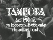 En ung man spelar flöjt omgiven av andra människor, följande titelskylt ligger över bilden: TAMBORA - en KF-film om kooperativ företagsamhet i hushållens tjänst.