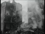 Bombade fastigheter ligger i ruiner i Helsingfors 1939, rökridå i förgrunden.