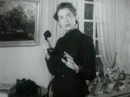 En kvinna som håller i en telefonlur av bakelit.