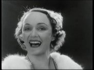 Närbild av Ulla Billquist som sjunger med öppen mun.