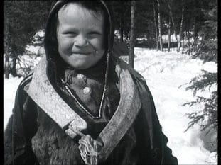 Gosse i traditionell samisk utstyrsel. Vinterlandskap i bakgrunden.