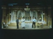 Tre skådespelare på en teaterscen.