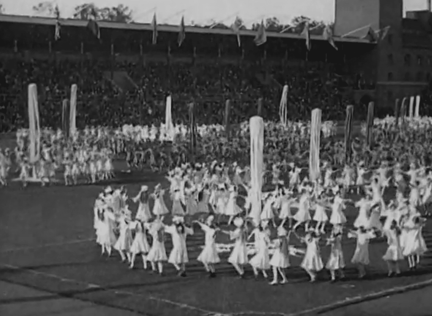 Massor av barn i ringdans på Stockholms stadion under Barnens dag 1921.