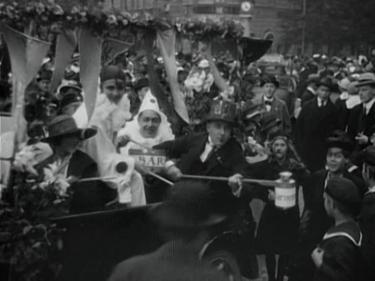 Ekipage med tiggarbössor under Barnens dag i Stockholm 1919, mängder av folk i bakgrunden.