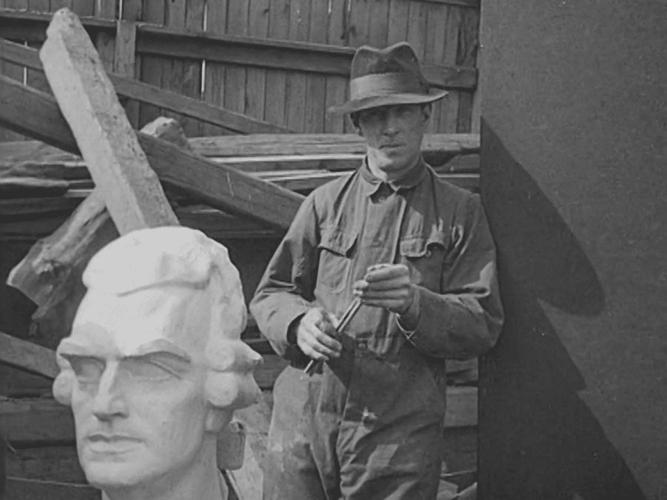 En arbetare poserar bakom en gipsavgjutning vilken använts för att färdigställa en byst av Fredric Henric af Chapman.