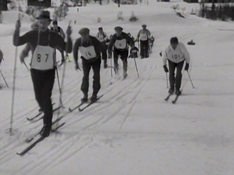 Ett tiotal skidlöpare med nummerlappar i spåret under det första Vasaloppet 1922.