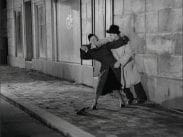 En kvinna tar ett jiu-jitsugrepp på en man på en trottoar.