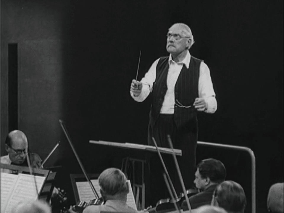 Stillbild ur journalfilmen Veckorevy 1949-09-12 som visar inspelningen av filmen Till glädje där Victor Sjöström dirigerar en orkester.