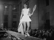 Mannekänguppvisning i Skandinaviska Banken vid Gustaf Adolfs torg, kvinnlig modell med tennisracket i hand.