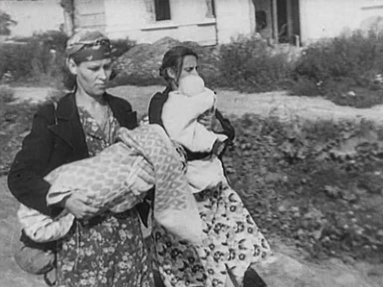 Två kvinnliga krigsflyktingar som bär på små barn.