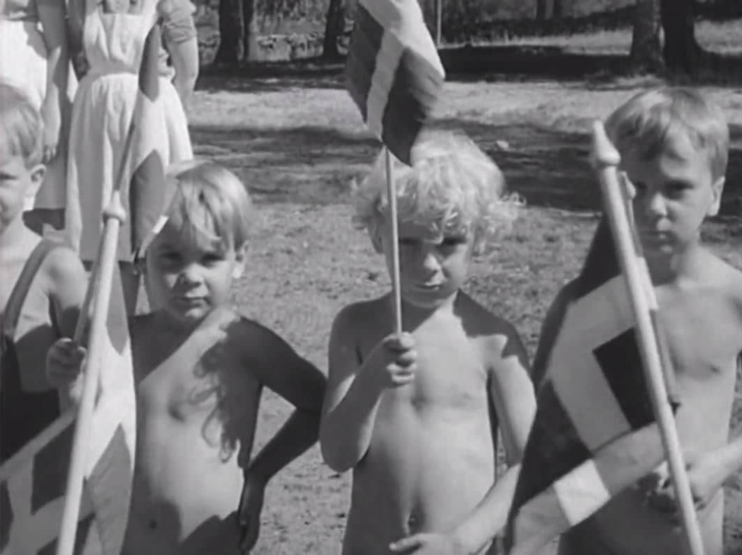 Små barn med svenska flaggor.