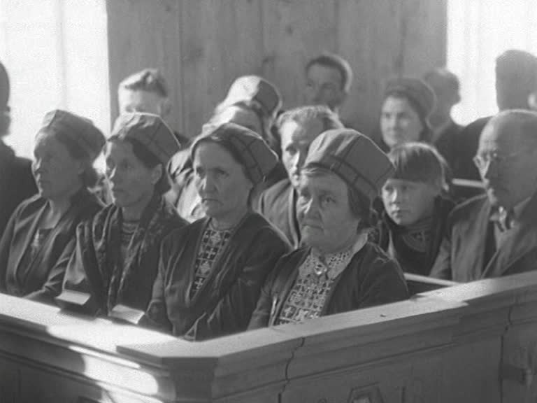 Sittande besökare i kyrkbänkar vid återinvigningen av Kolåsens samiska kapell 1949.