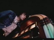 Magnus Uggla framför en jukebox filmad underifrån.